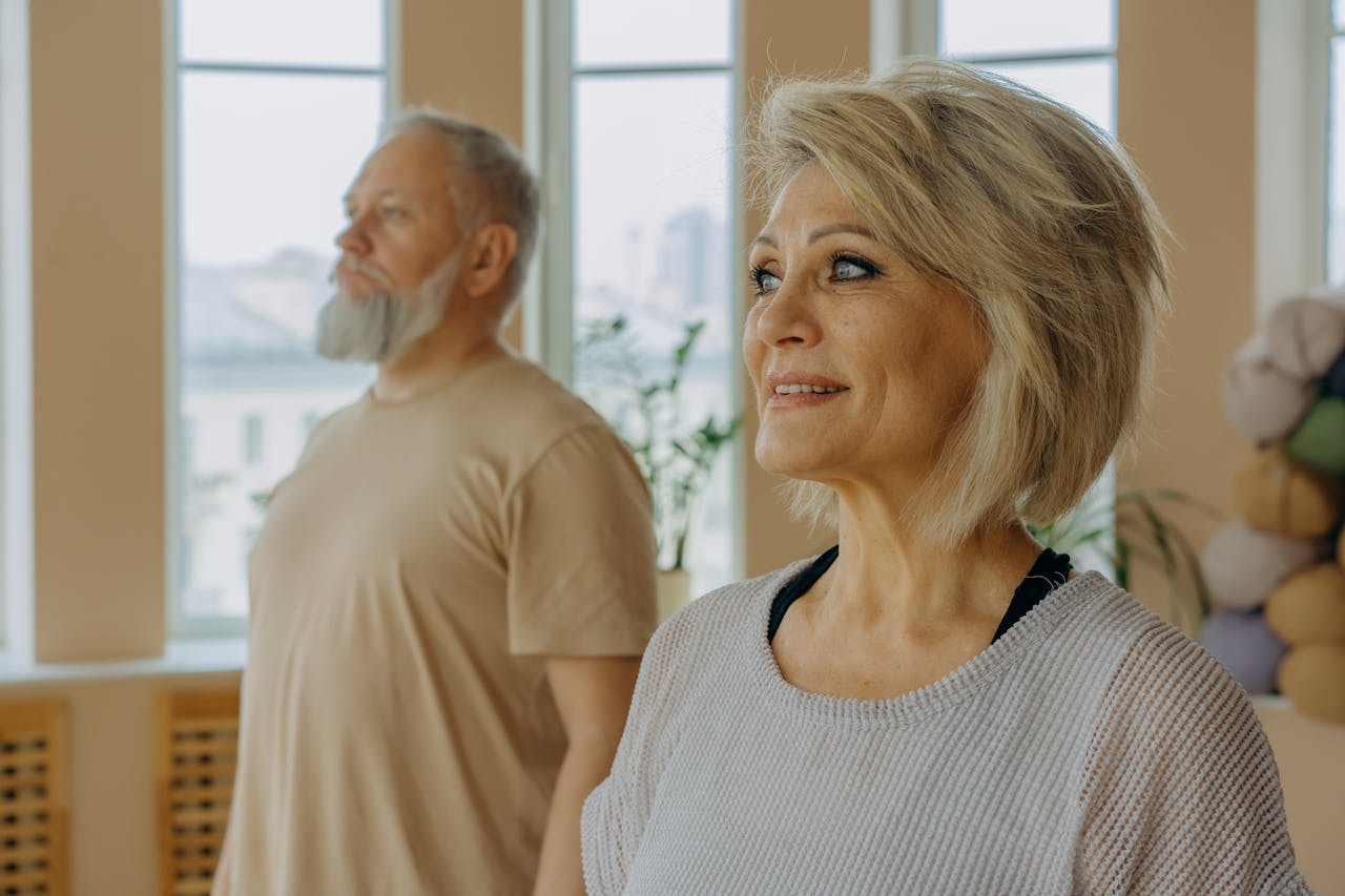 Woman in White and Black Striped Tank Top Standing Beside Man in Beige Crew Neck T